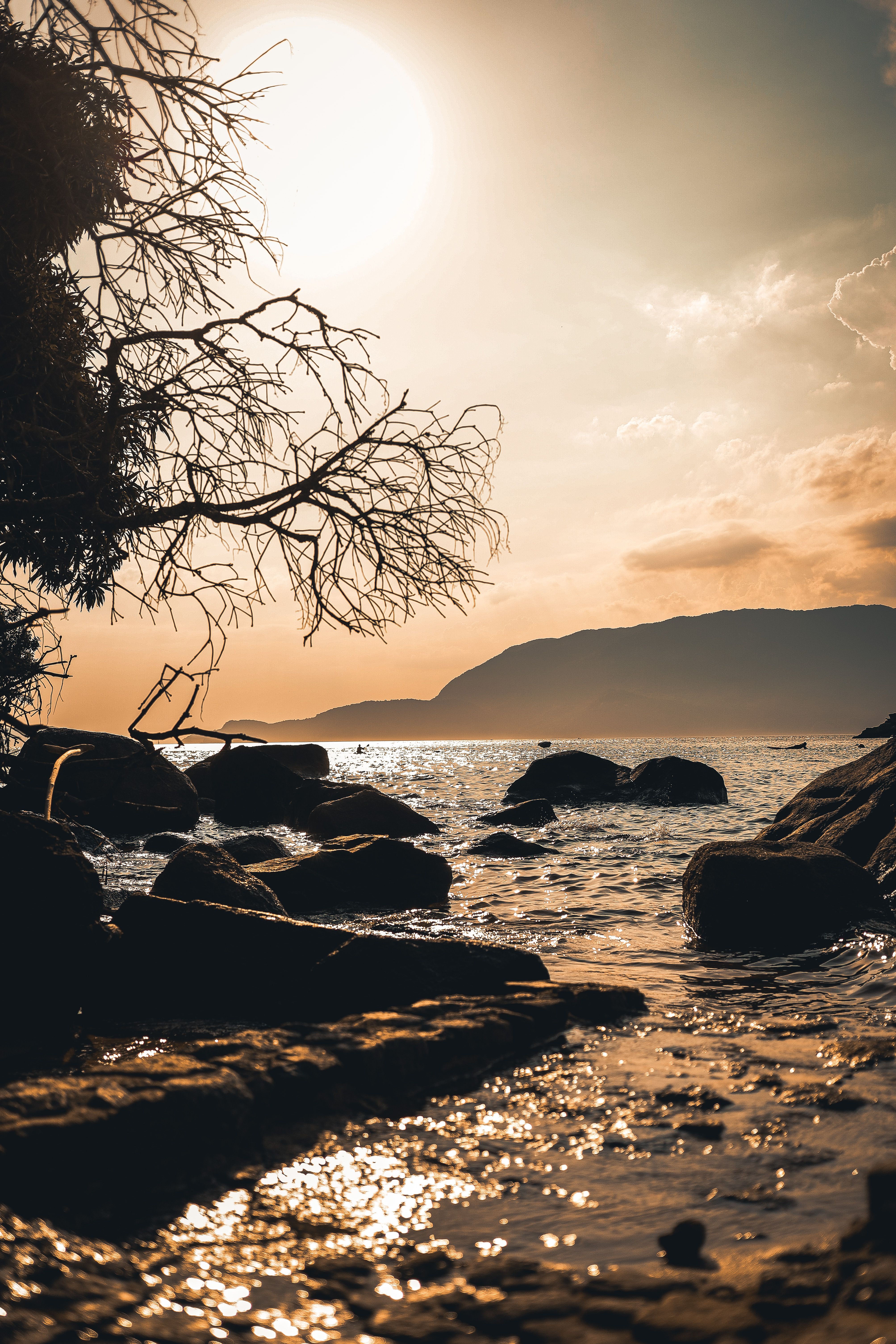 Sun Setting over Coastal Boulders · Free Stock Photo