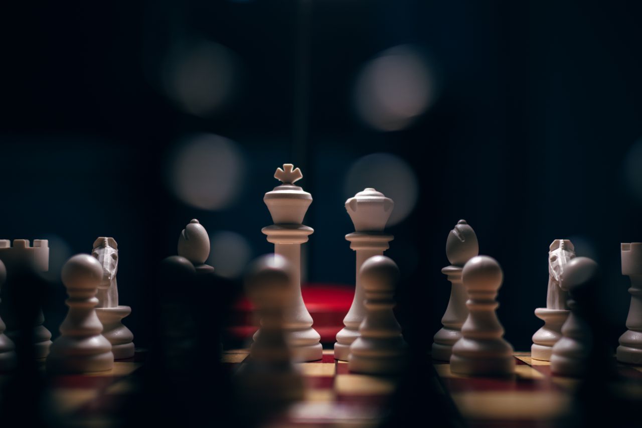 close up of a chessboard in low light focusing on white chess pieces c