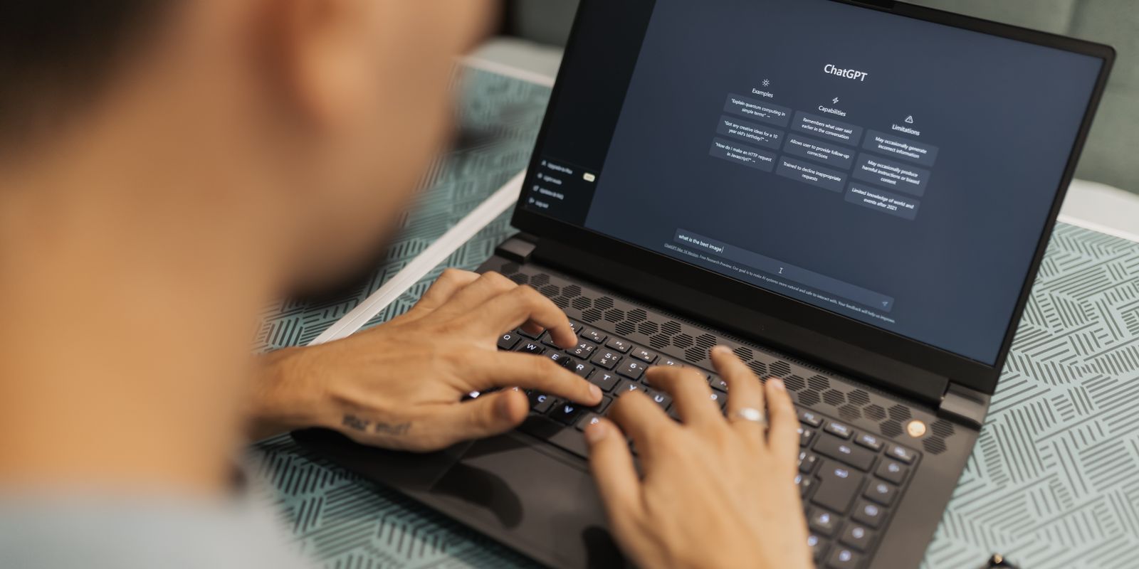 A person typing on a laptop while using an AI chat assistant