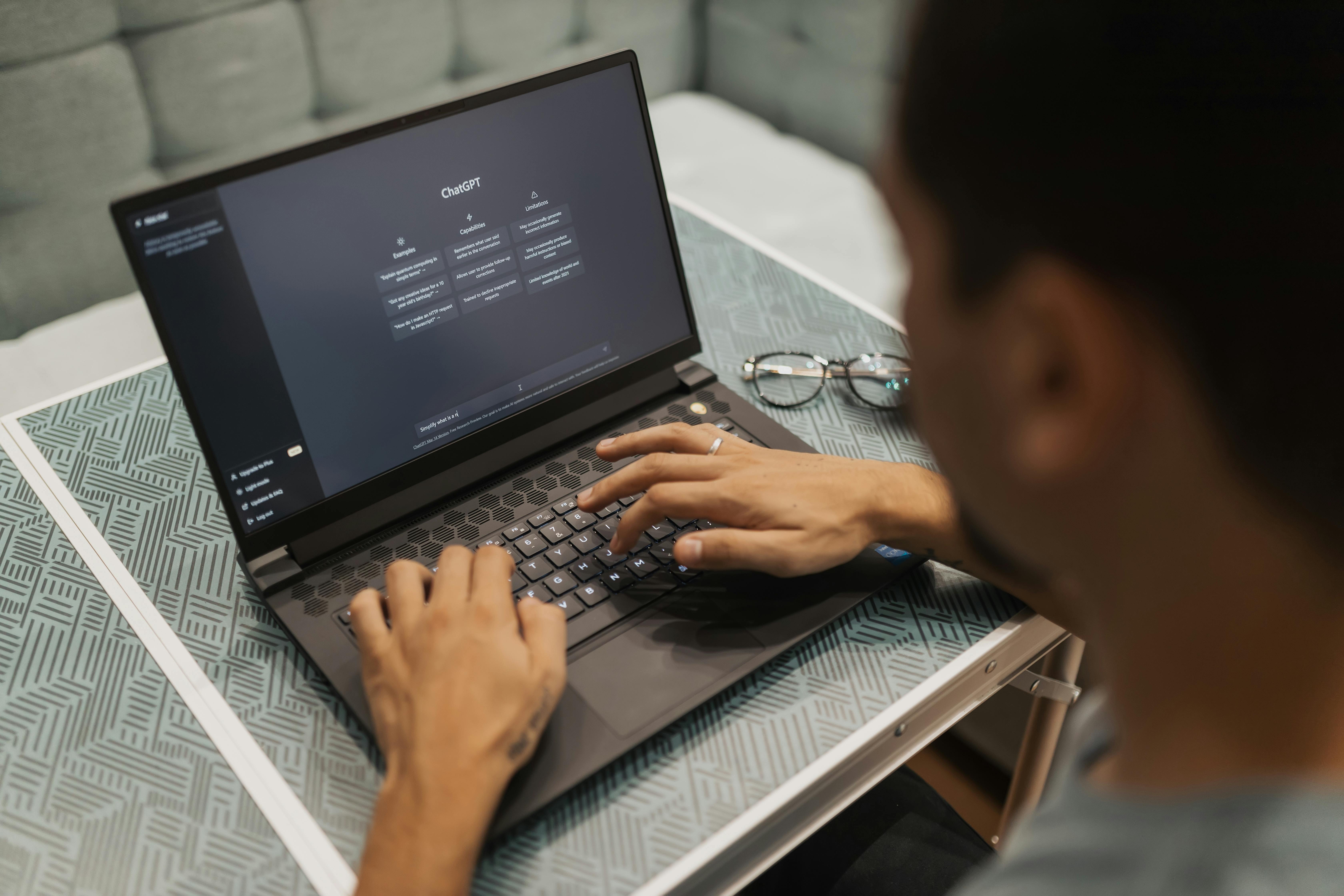 Free A person using a laptop to interact with AI technology indoors during the day. Stock Photo