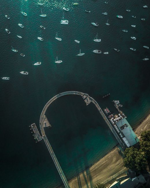 Aerial shot of boats anchored near Mosman pier, showcasing a serene ocean view in NSW, Australia.