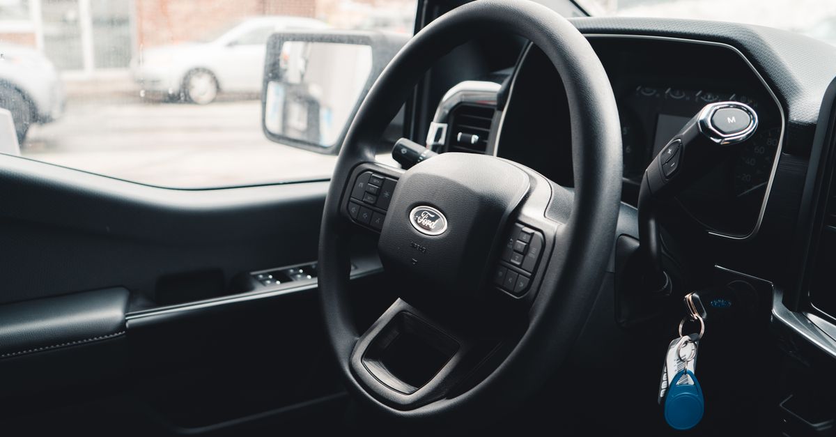 Interior view of a Ford vehicle showing steering wheel, dashboard, and car keys for modern automotive design.