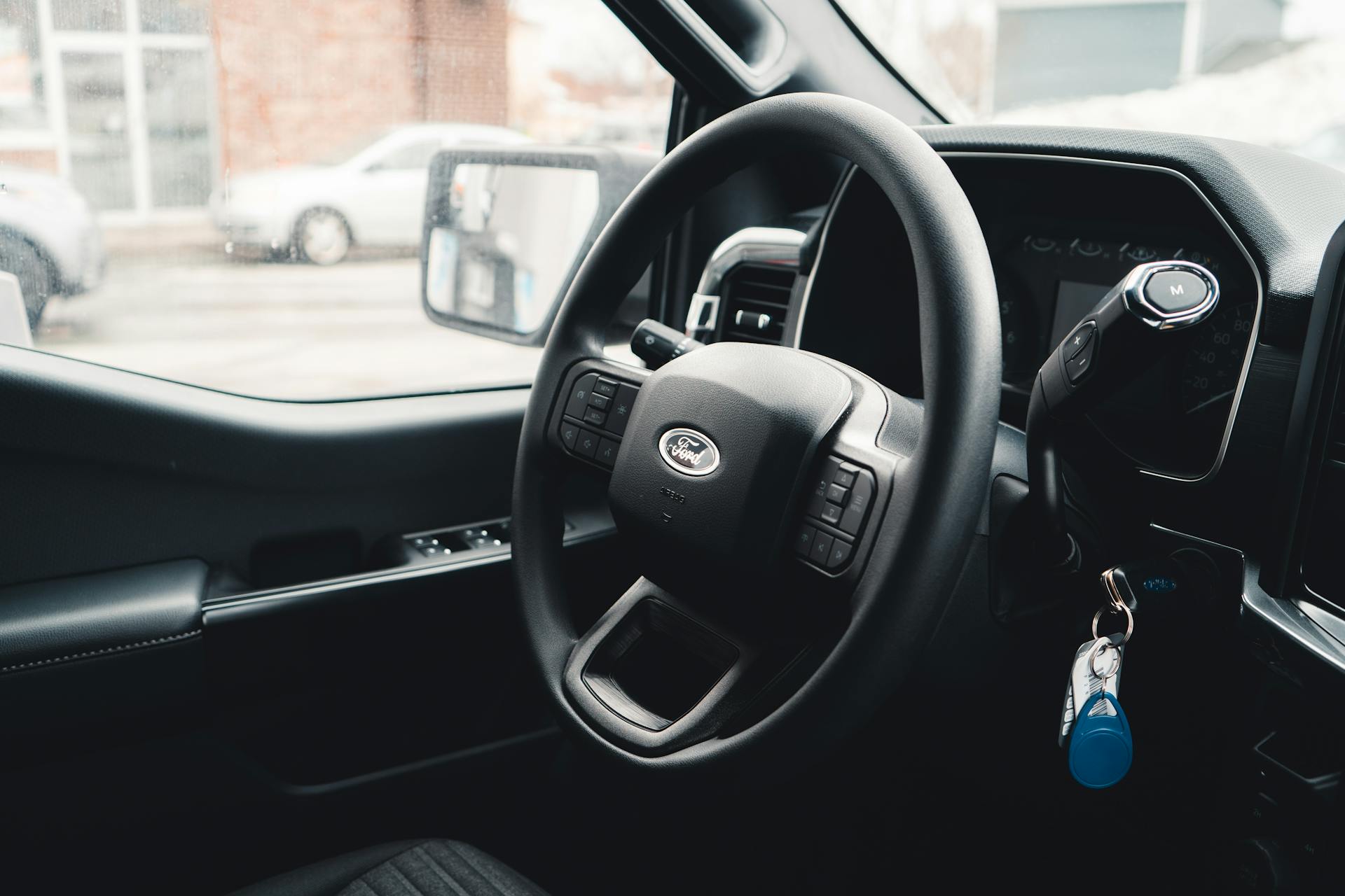 Interior view of a Ford vehicle showing steering wheel, dashboard, and car keys for modern automotive design.