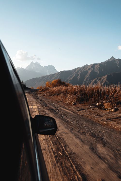 Free Driving through the picturesque mountains of Georgia on a serene dirt road at dusk. Stock Photo