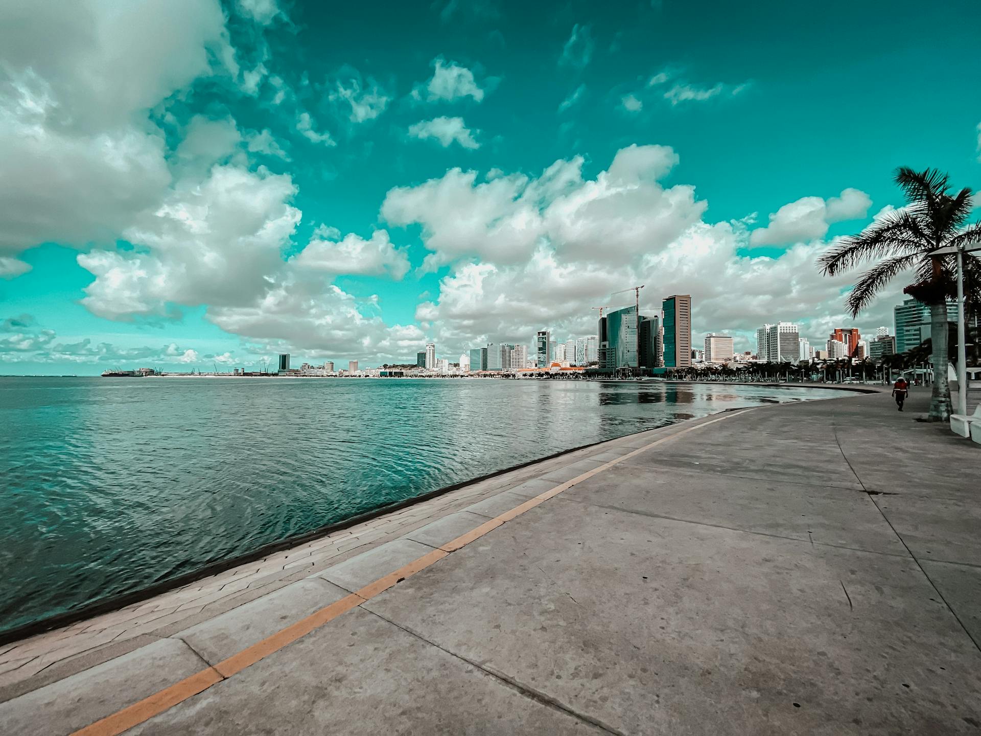 Beautiful bayfront view of Luanda, Angola with clouds and skyline reflection.