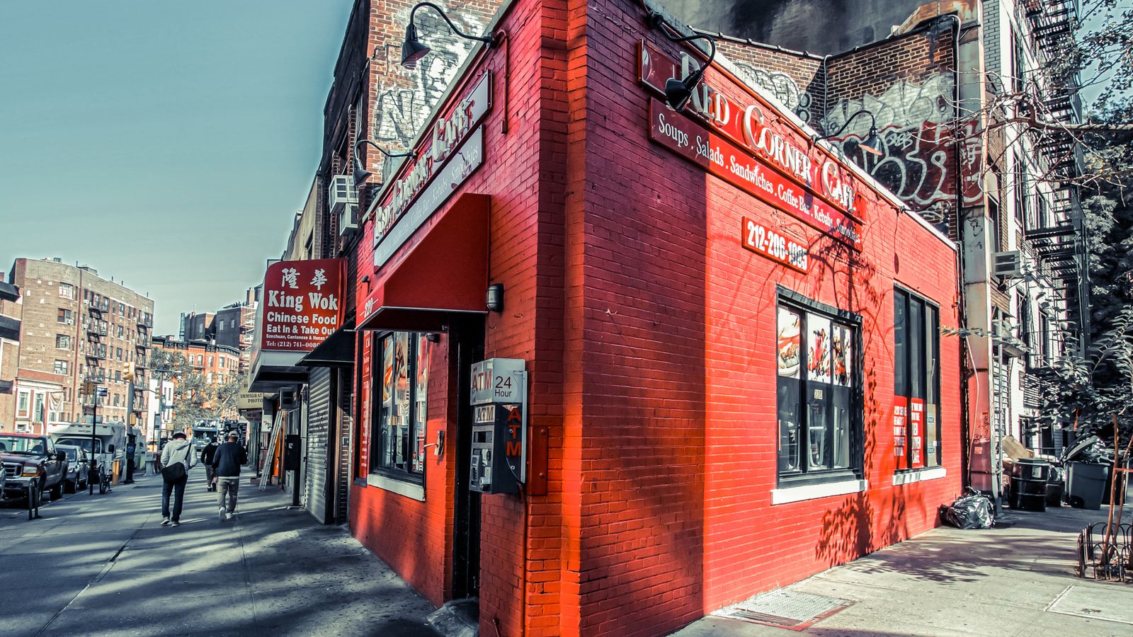 Vibrant red corner cafe in bustling New York City, capturing urban life.