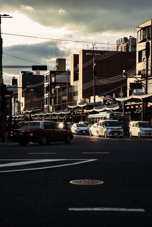 Free Atmospheric view of Kyoto city street with traffic and urban buildings during dusk. Stock Photo