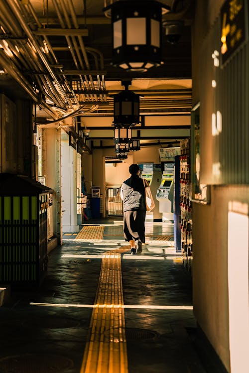 Back View of a Pedestrian Walking in a Passageway in City 