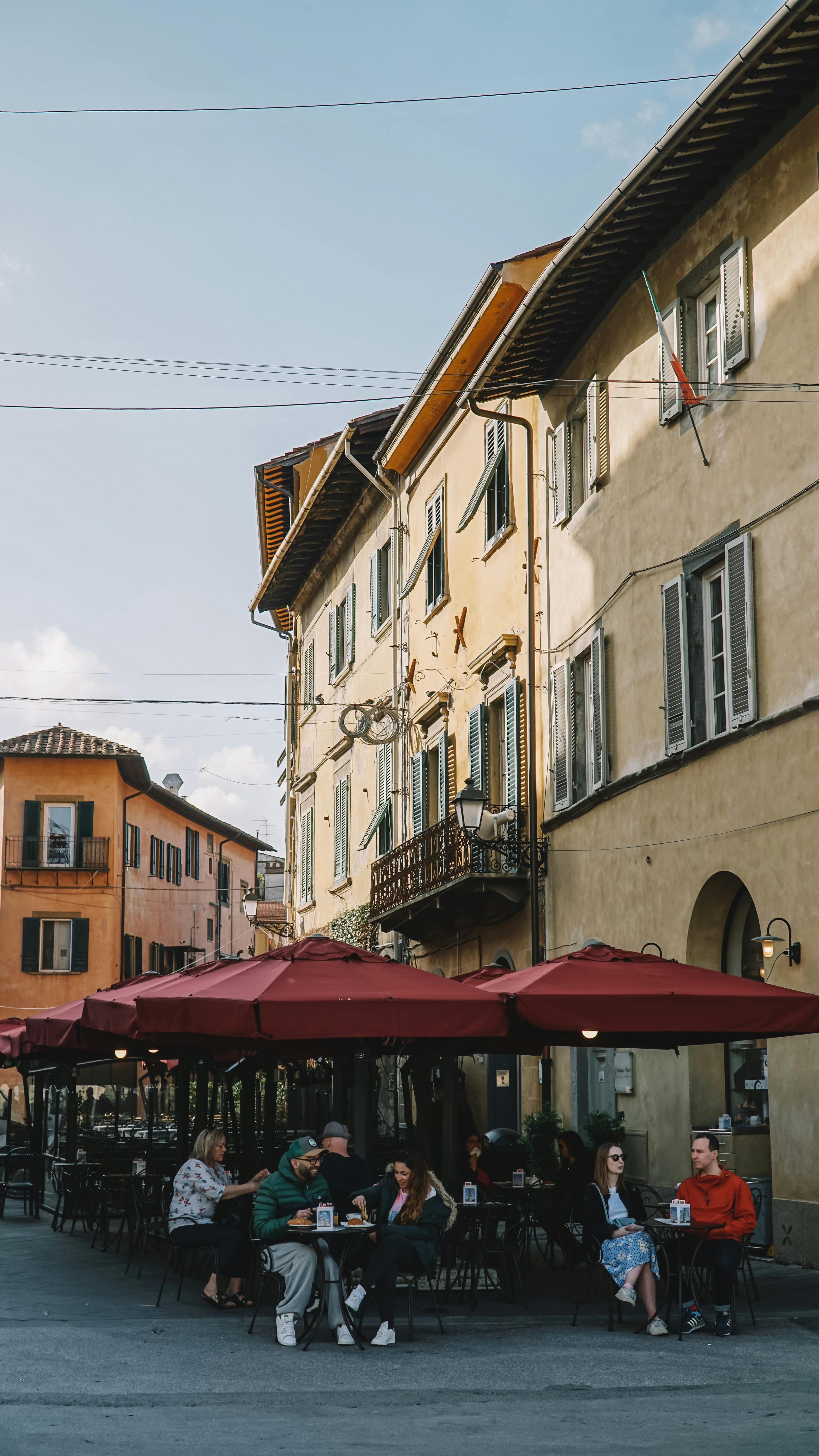 Enjoy a sunny day at an outdoor café in historic Pisa, Tuscany, Italy, with vibrant architecture.