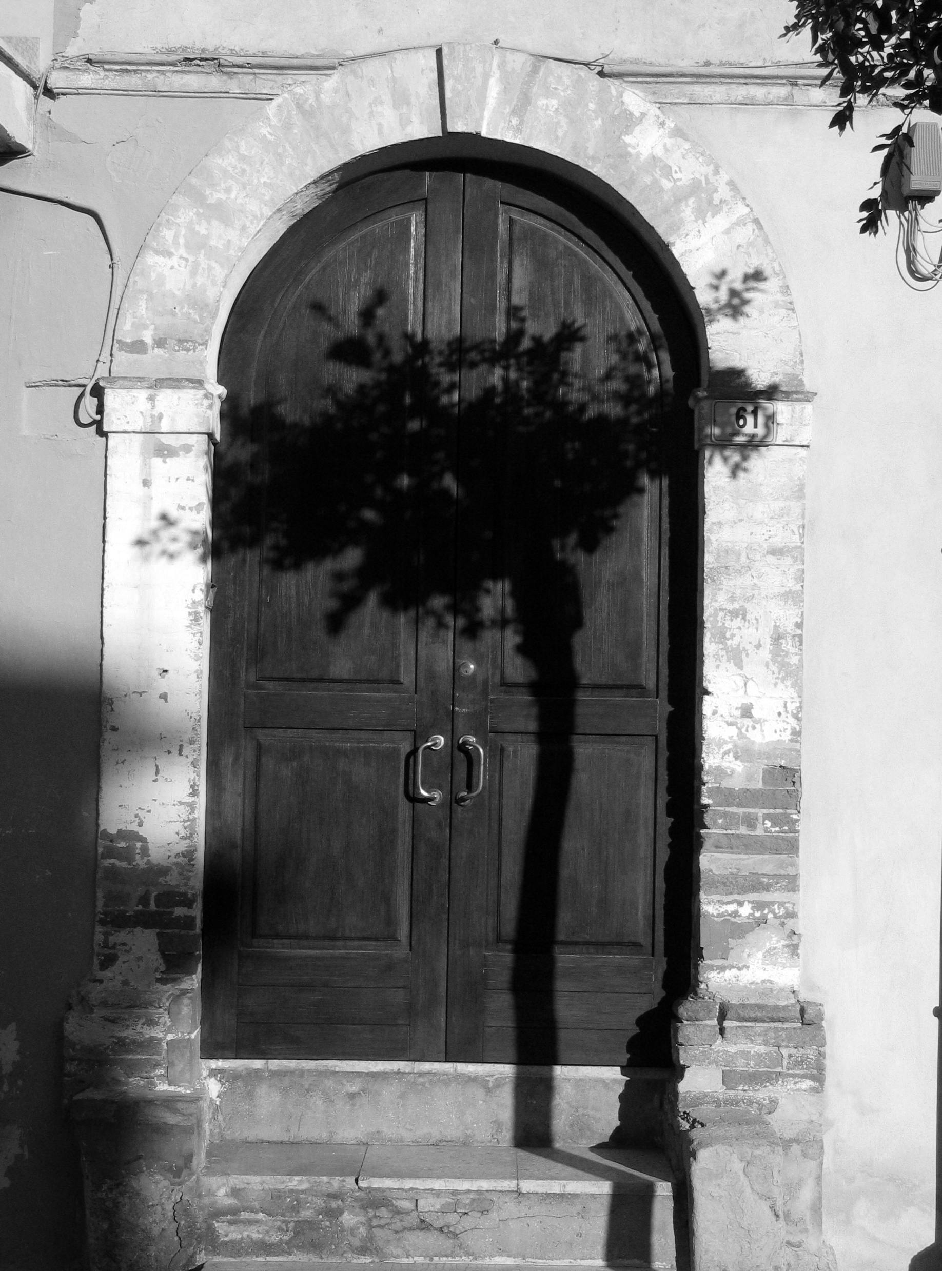 a black and white photo of a door with a shadow