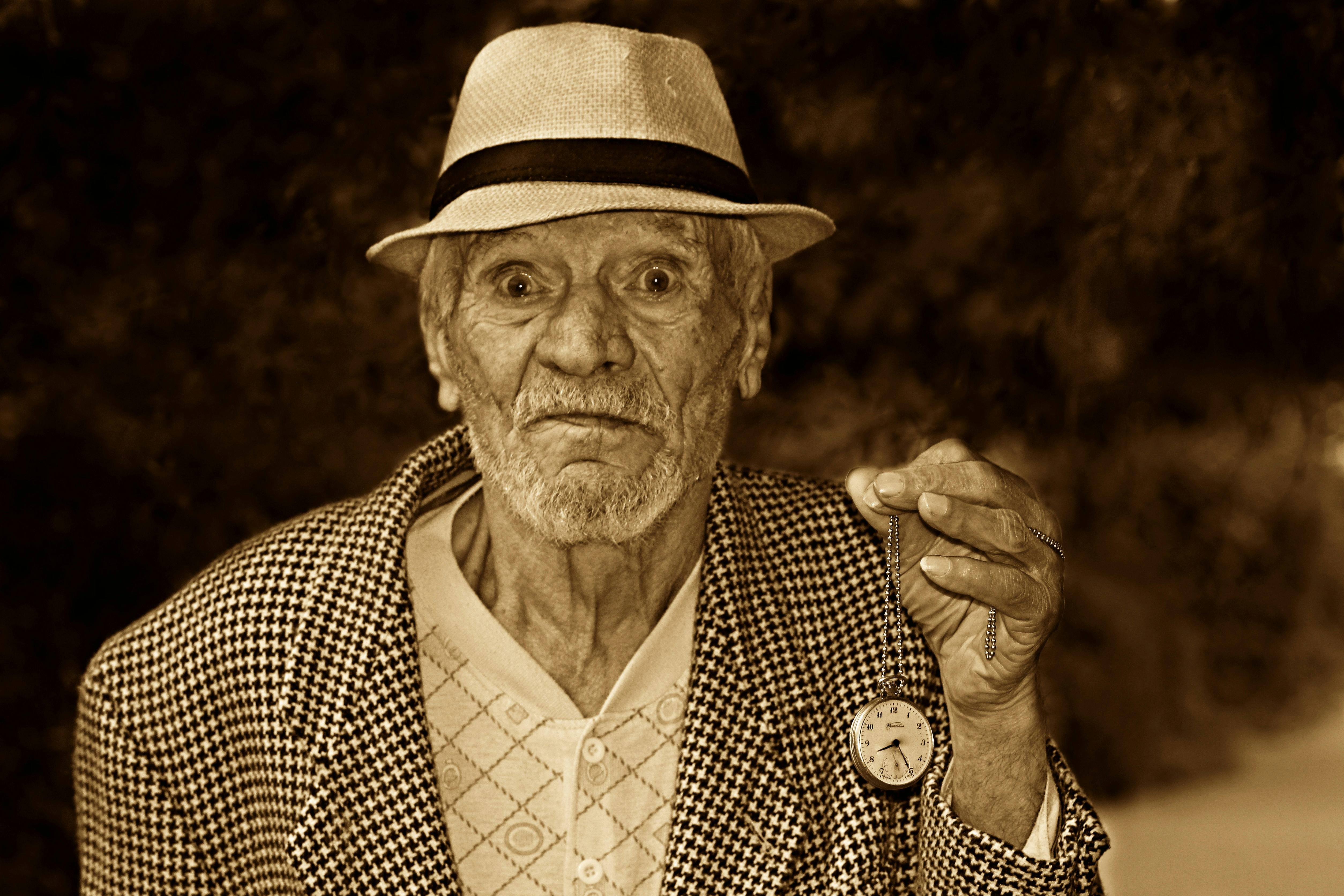 man-holding-pocket-watch-in-grayscale-free-stock-photo