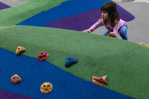 Young girl climbing on a colorful playground in Zagreb, Croatia.