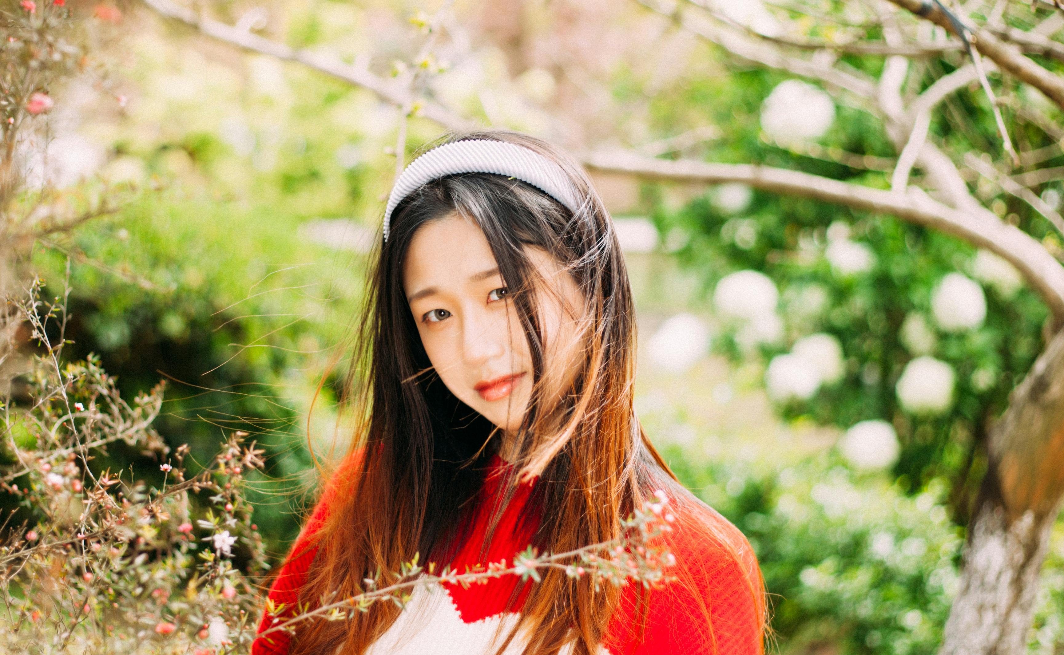 Charming portrait of a young woman in a vibrant garden setting.