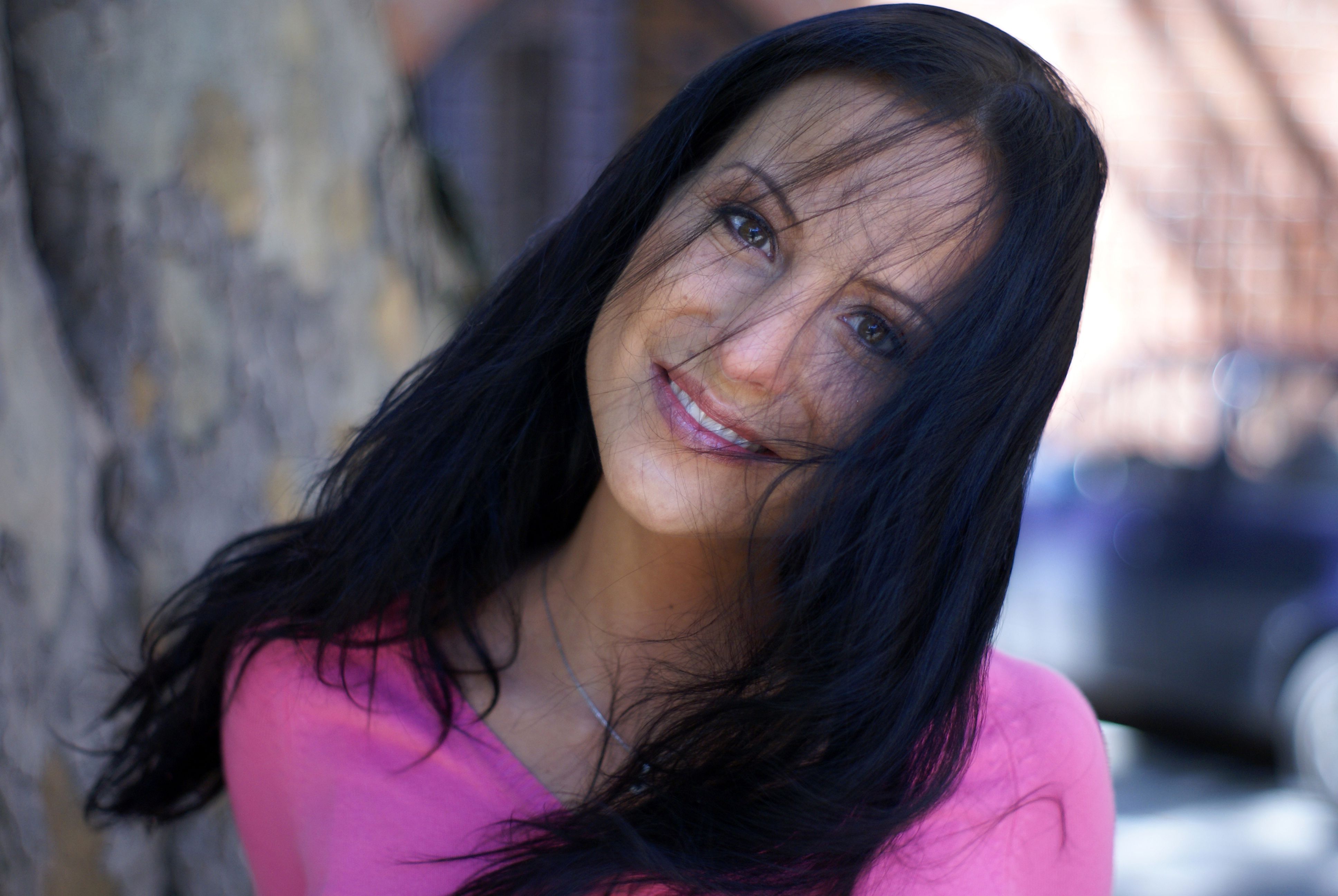 A woman with long black hair smiling for the camera · Free Stock Photo