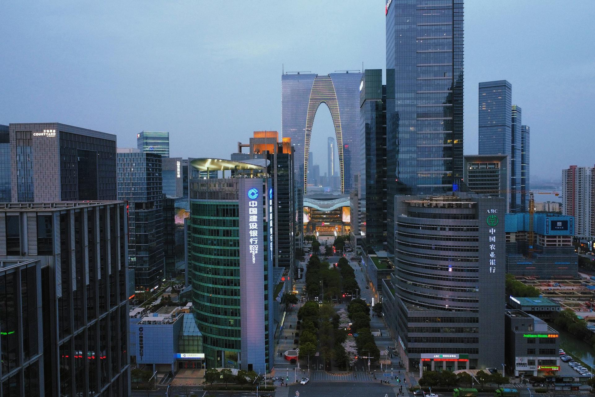 Stunning modern architecture of Suzhou's Gate to the East at dusk, showcasing a vibrant financial district.