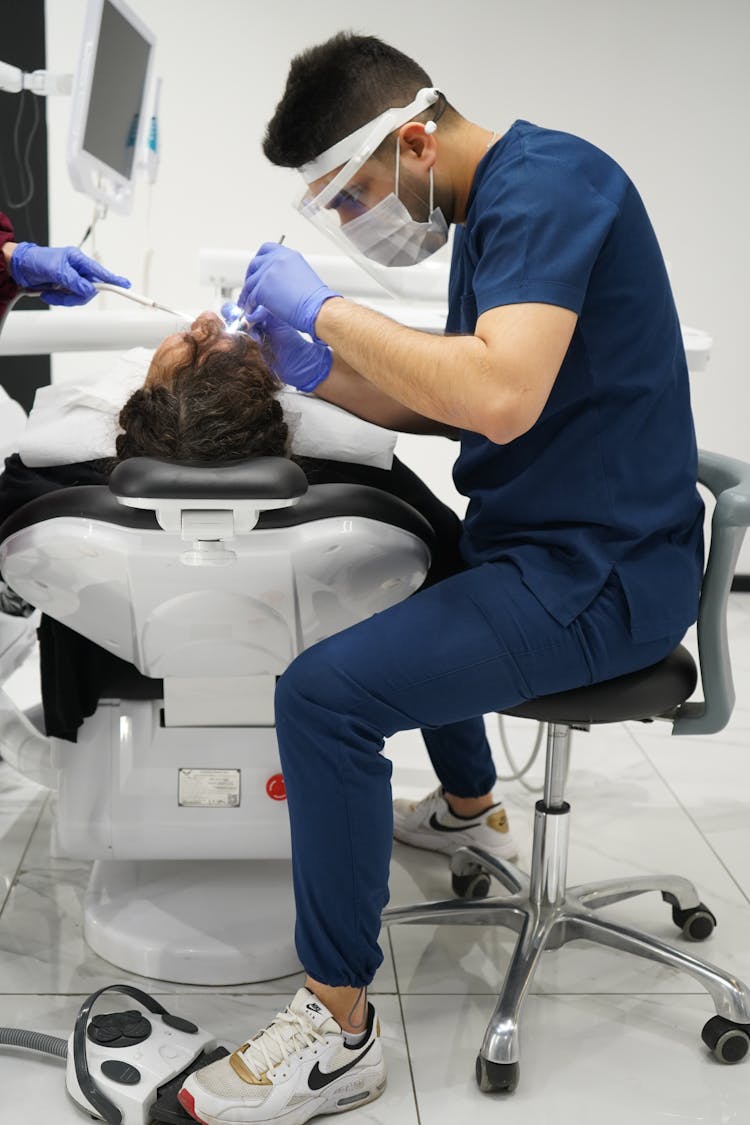 Male Dentist Treating A Patient