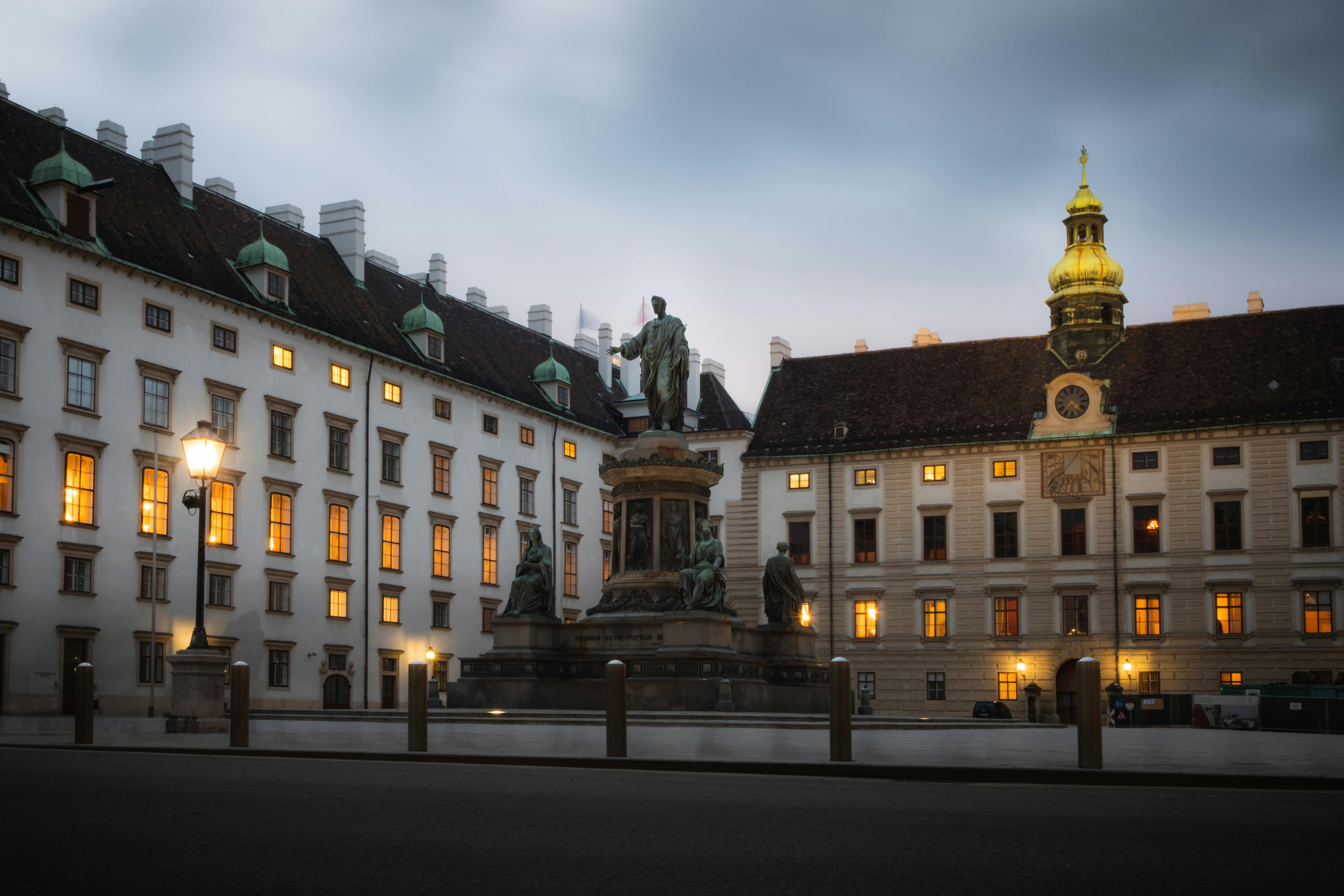 a statue is in front of a building at dusk