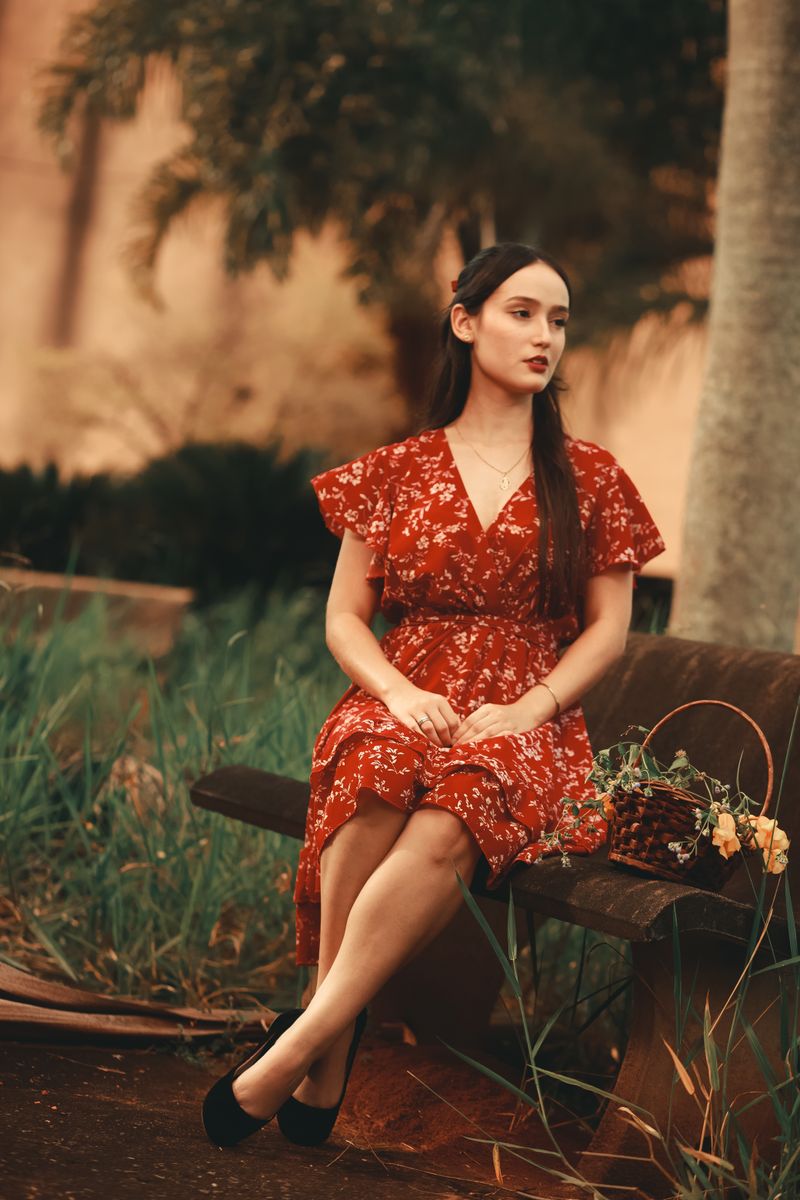 Woman in a Red Dress Sitting Alone on a Park Bench · Free Stock Photo