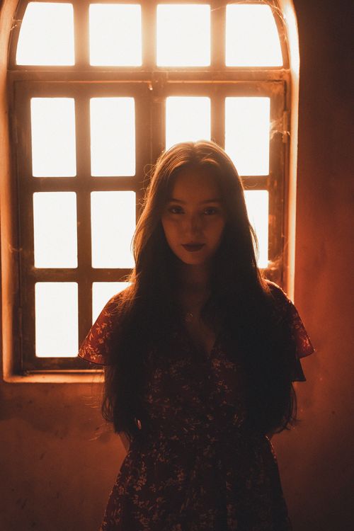 Free Mystical portrait of a woman with long hair backlit by sunlight through a window. Stock Photo