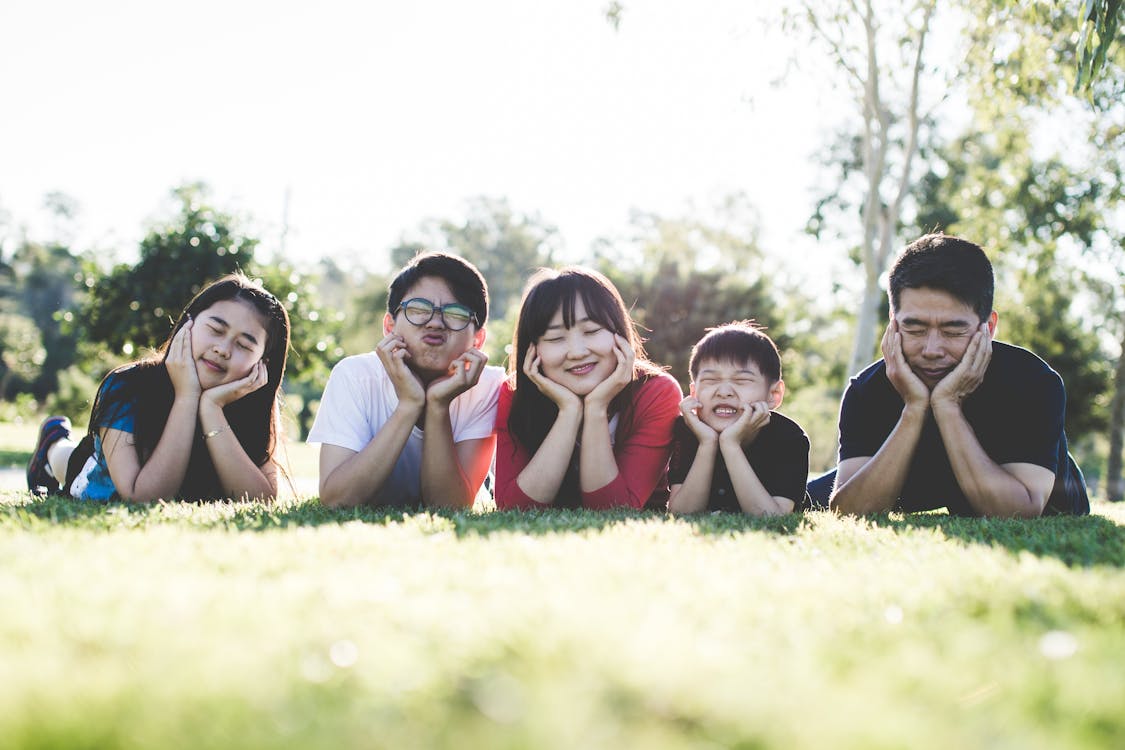 family laying on the grass to get vitamin D