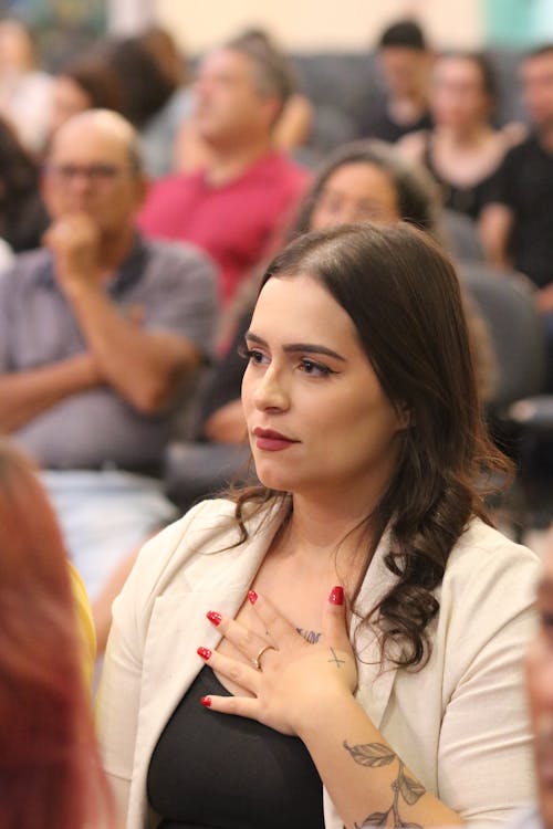 Young Woman in the Crowd Holding Her Hand on Her Chest 