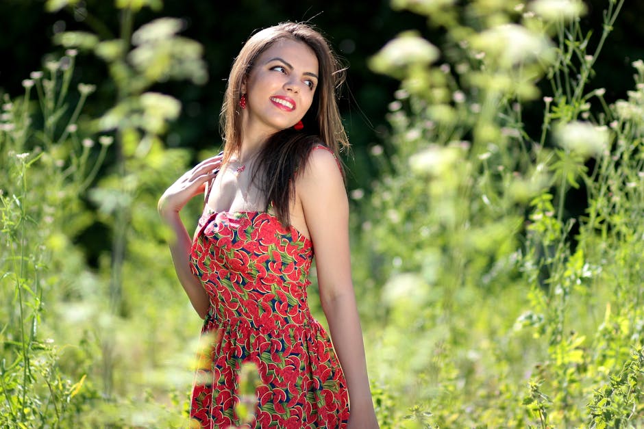 Smiling Woman in Pink Black and Green Floral Tube Dress Near Green Leaf Plants during Daytime