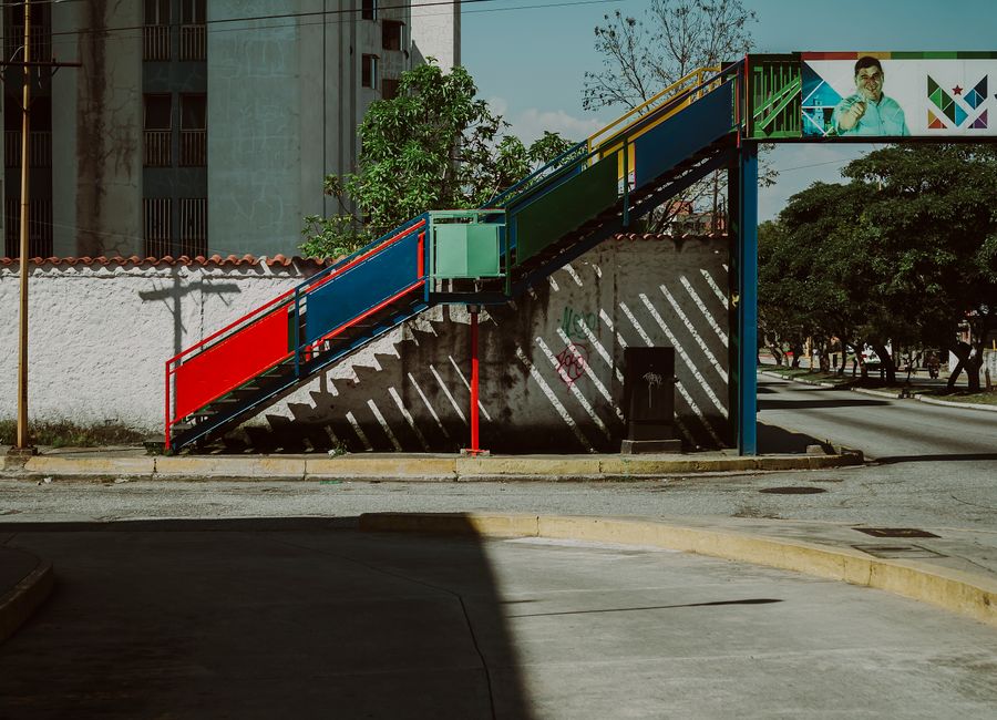 A vibrant pedestrian bridge over quiet urban streets in Mérida, Venezuela.