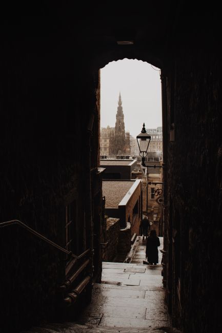 Stunning Edinburgh alleyway with view of historic building spire on a moody day.