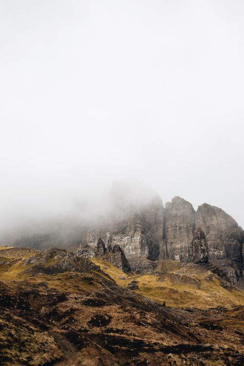 Free Ethereal view of fog-laden mountains in the Scottish Highlands, showcasing nature's serene beauty. Stock Photo