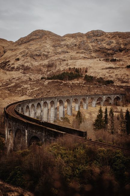 Stunning view of the Glenfinnan Viaduct amid the autumn landscape in Scotland. Perfect for travel and nature enthusiasts.