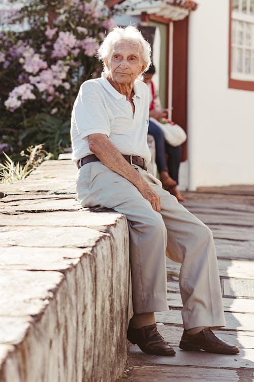 Man Sitting on Wall in Town