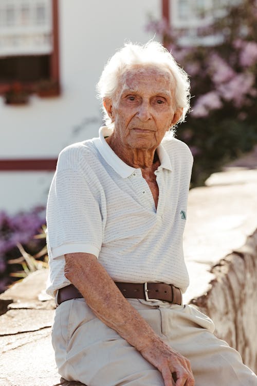 Elderly Man Sitting on Wall