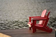 木制码头上，两把红色的阿迪朗达克椅子俯瞰着宁静的水域，非常适合放松身心