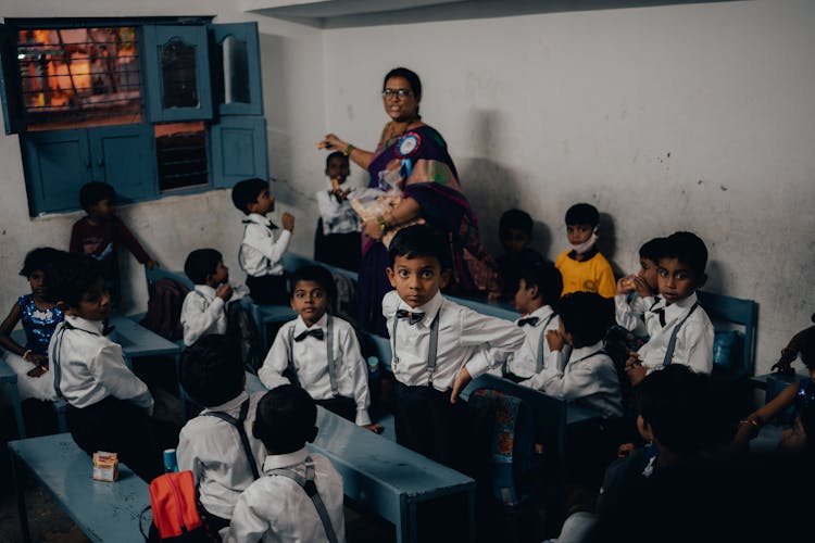 Teacher Handing Out Juice Boxes To Pupils In A Classroom