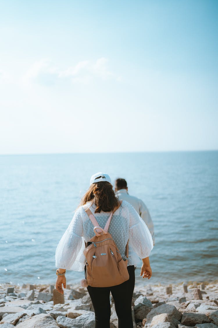 Couple Walking On Stony Beach