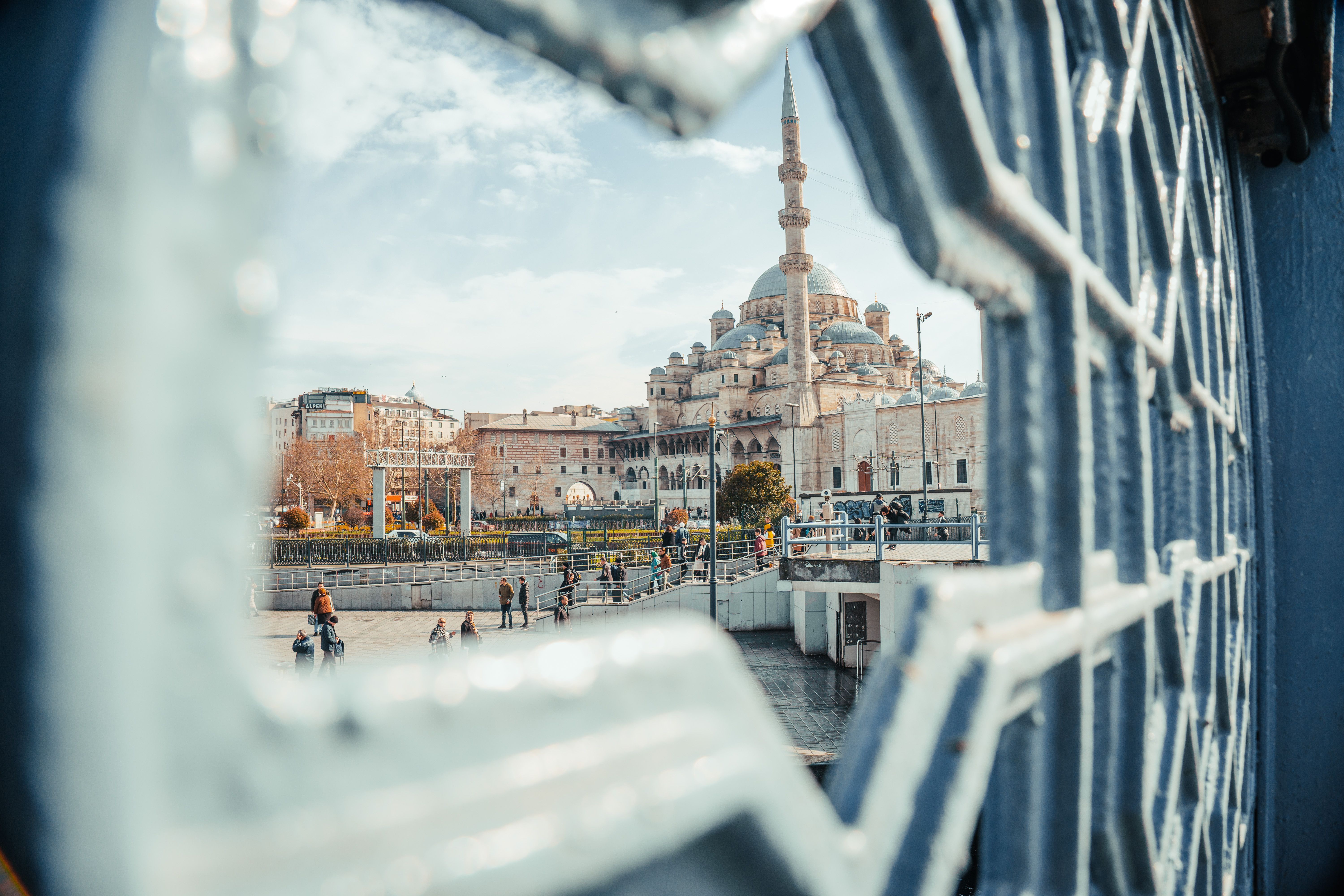 Artistic perspective of İstanbul's Süleymaniye Mosque through ornate ironwork on a bright day.