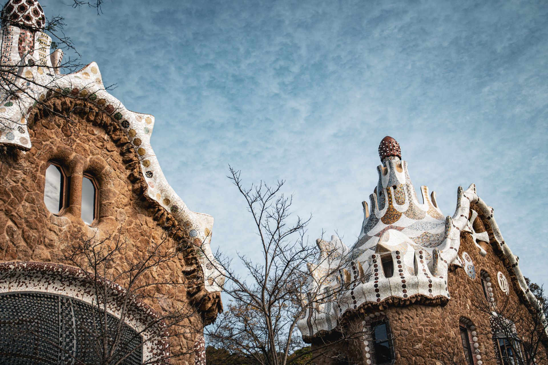 Beautiful view of Gaudi's architectural design at Park Güell in Barcelona, showcasing unique stone and ceramic work.