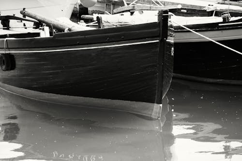Gray Scale Photo of Boat on Body of Water