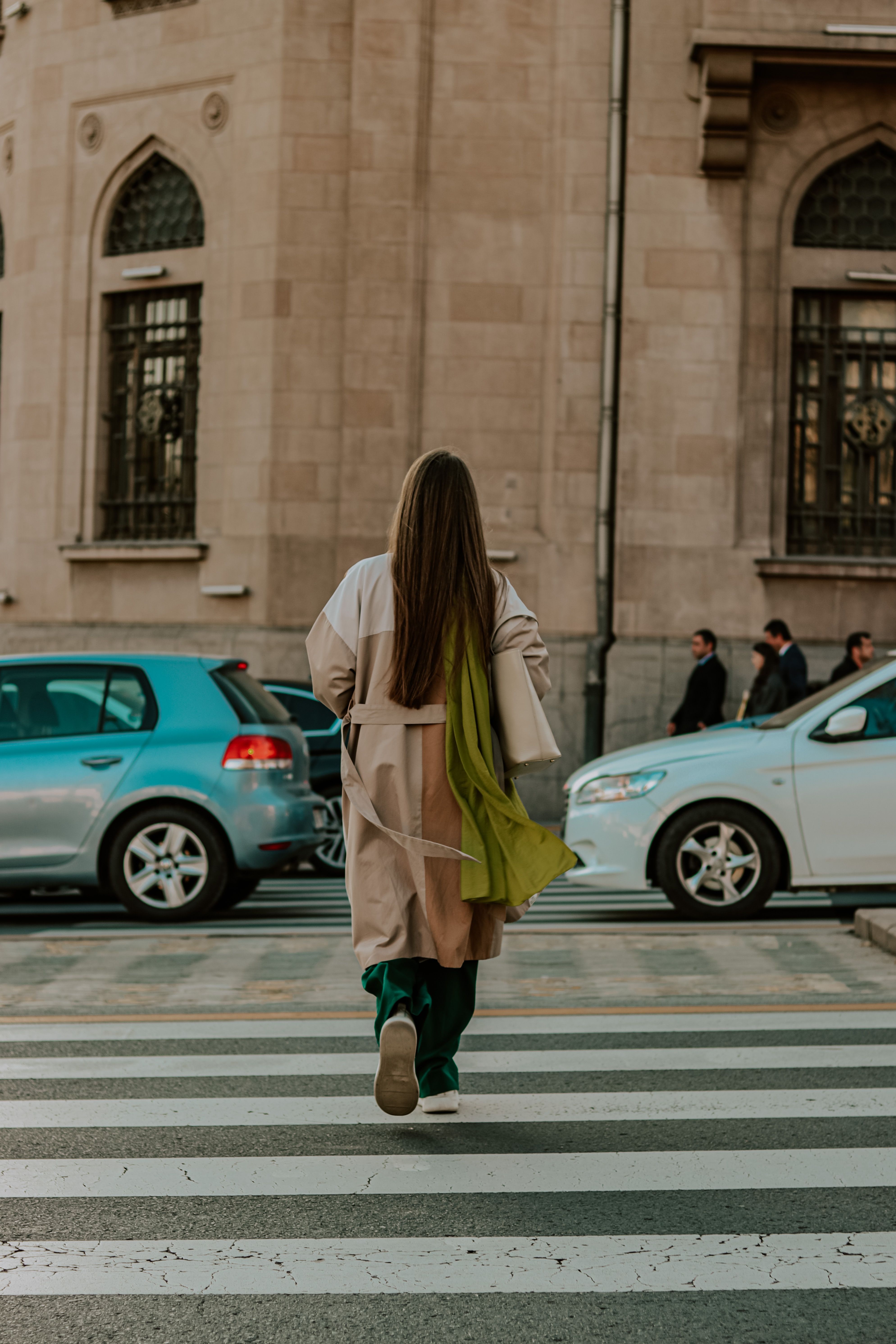 A woman walking across a crosswalk in front of a building · Free Stock ...
