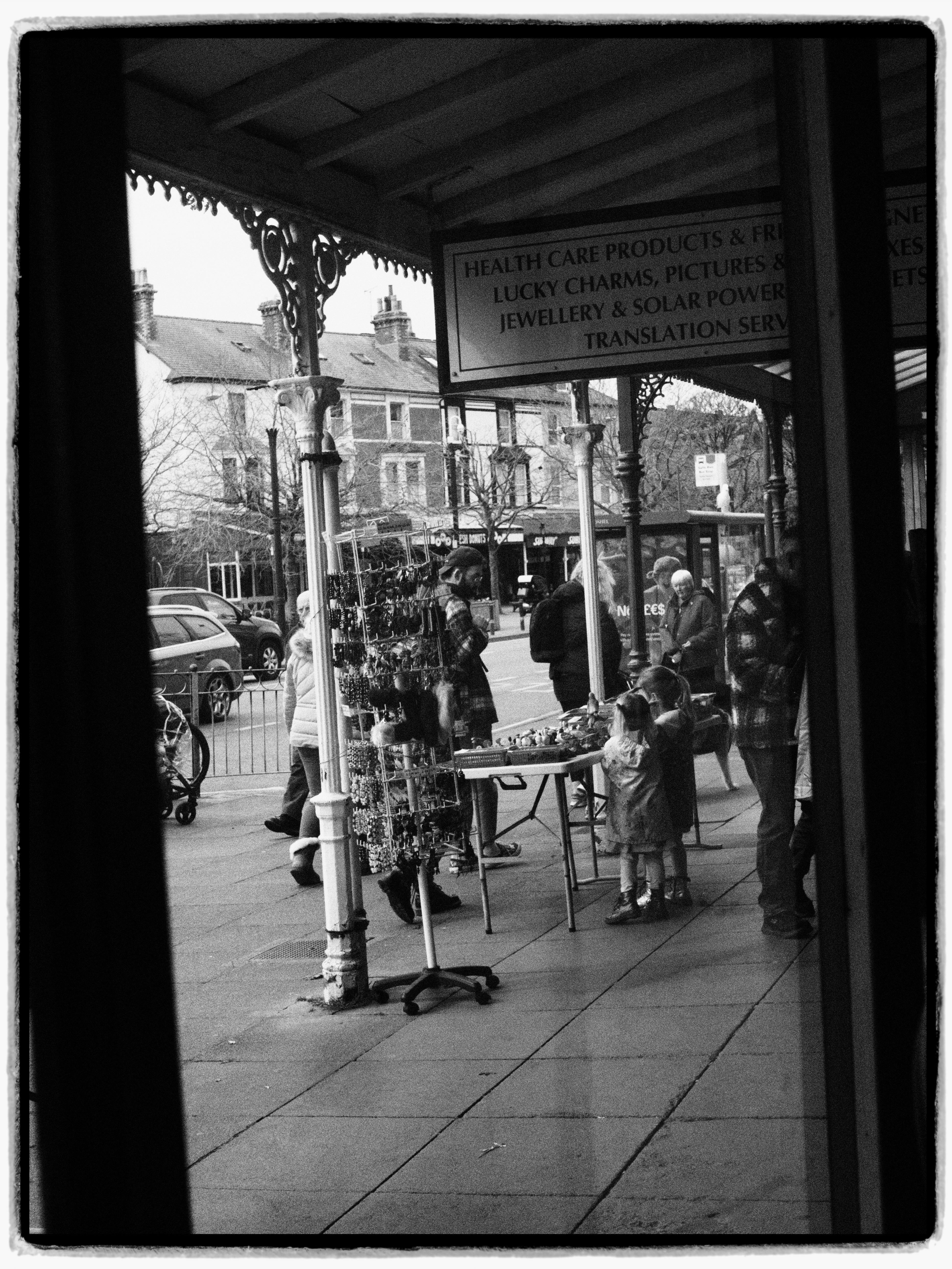 Black and white street scene in Llandudno, Wales showcasing vibrant market life.
