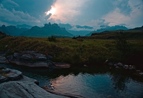 Free Breathtaking view of a river flowing through a mountain range during sunset, showcasing nature's serene beauty. Stock Photo