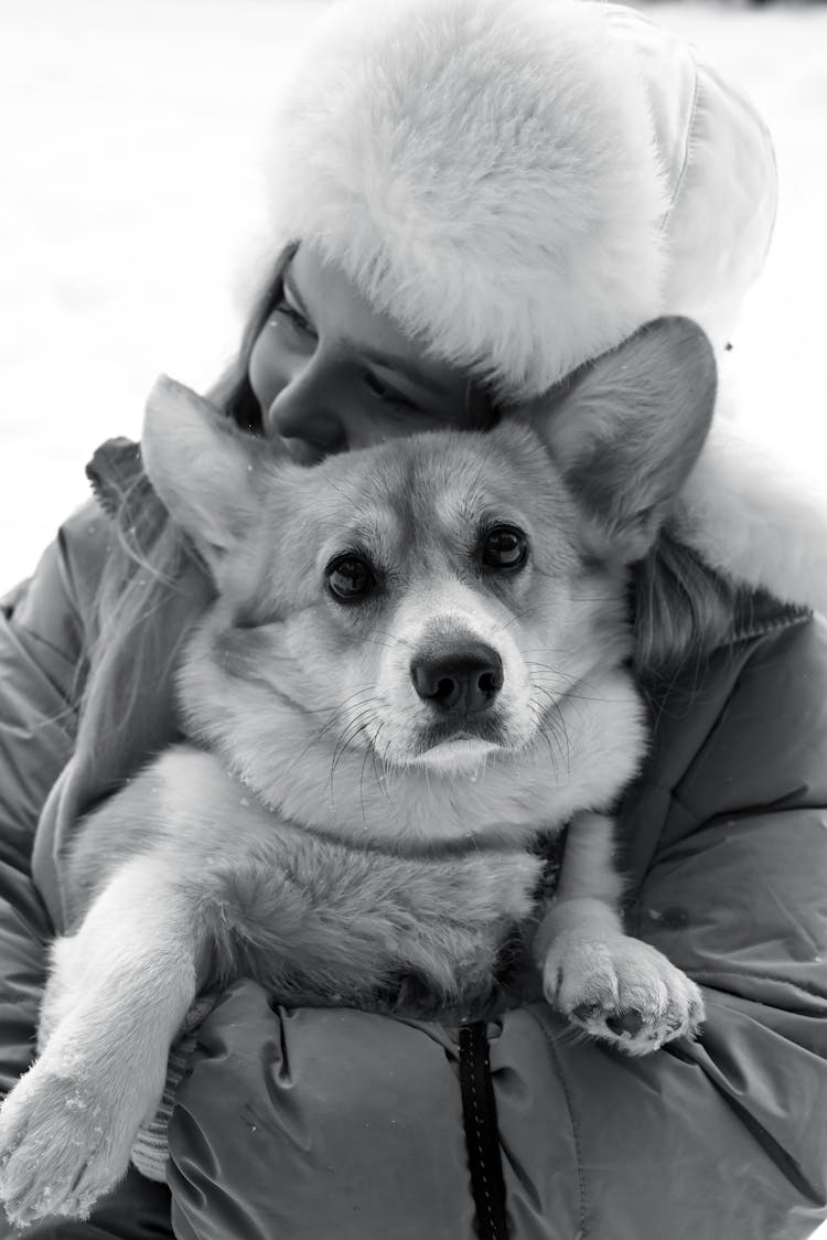 Black And White Picture Of A Woman Hugging Her Corgi Dog 