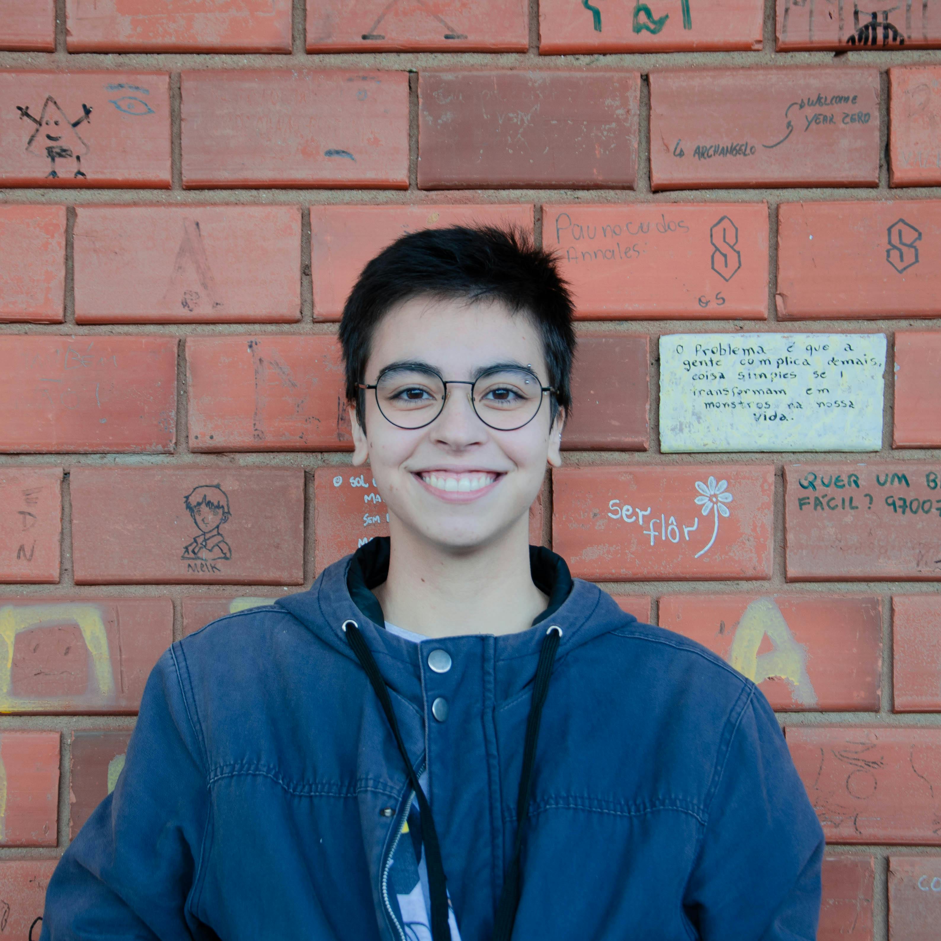 Smiling Woman against Brick Wall · Free Stock Photo