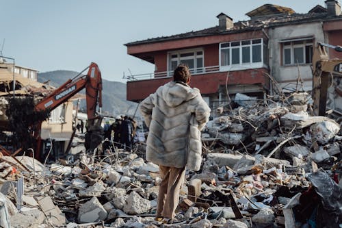 Shocked Woman in Fur Standing among Ruins