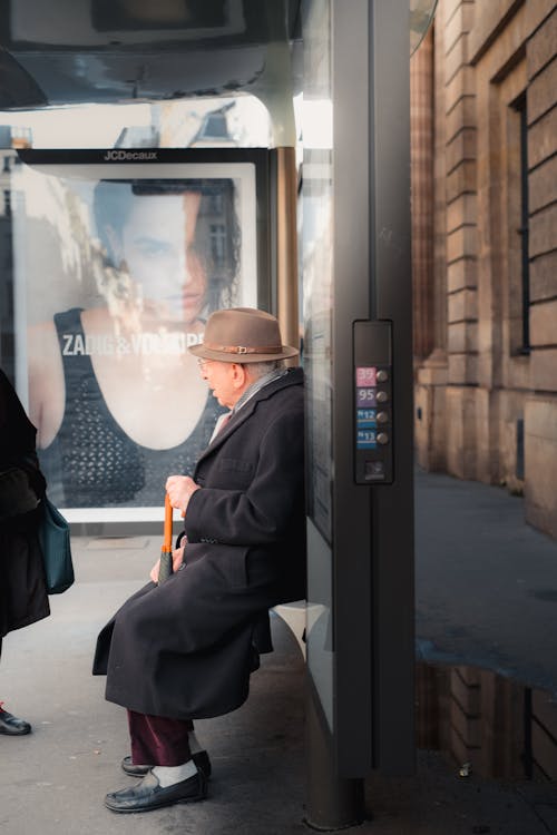 Elderly Man Sitting on Bus Stop