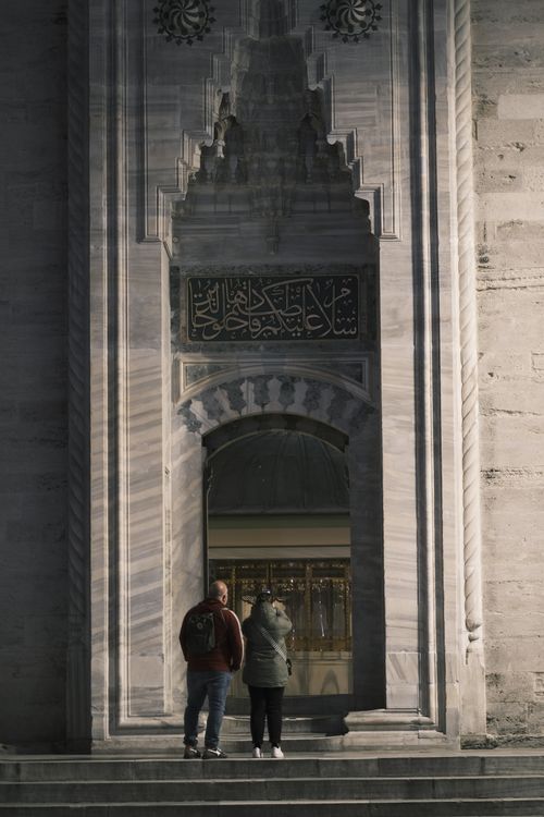 Free Tourists visiting the Suleymaniye Mosque entrance in Istanbul on a sunny day. Stock Photo