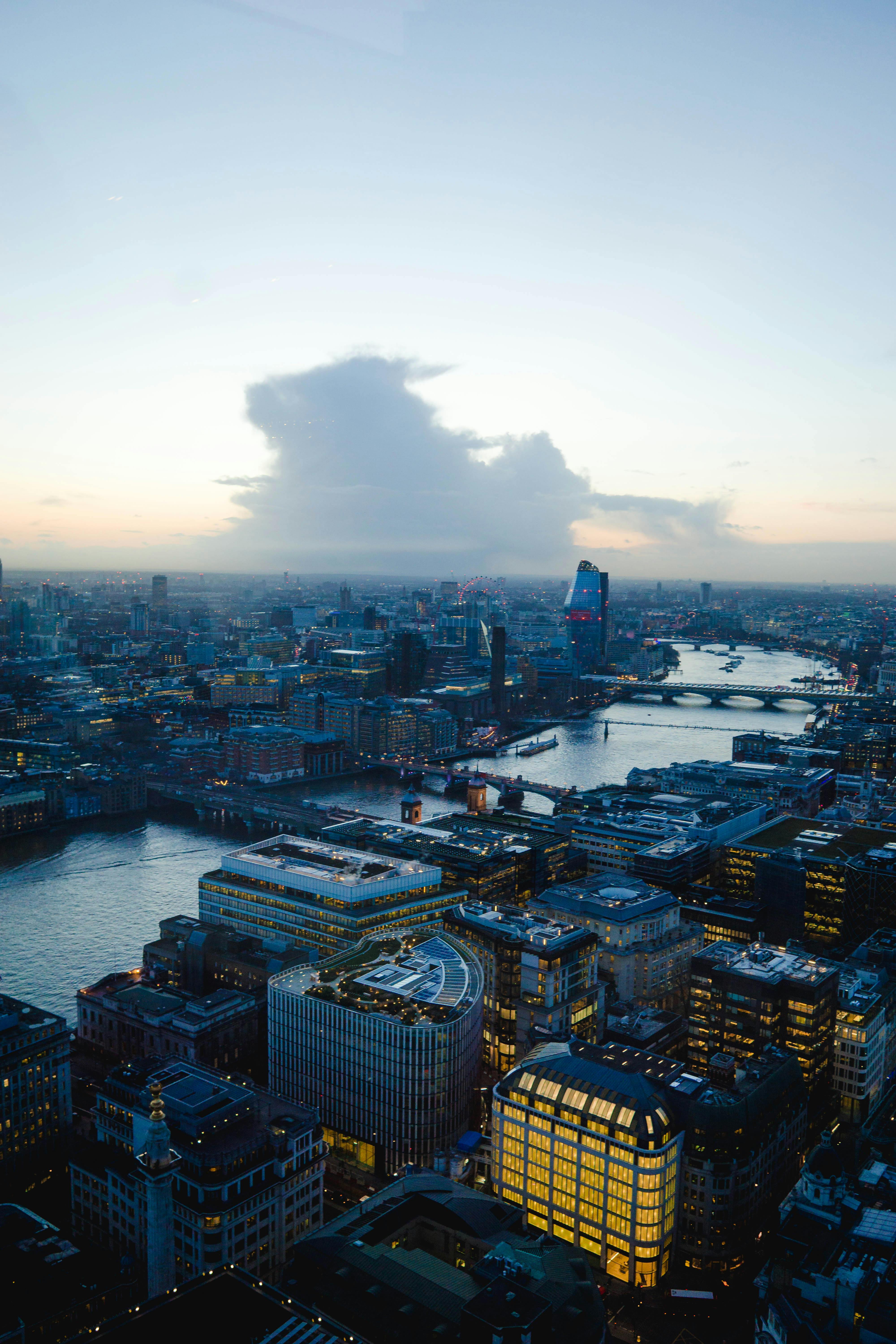 伦敦的天际线在黄昏中格外壮观，摩天大楼耸立，河流静静流淌，构成一幅令人惊叹的鸟瞰图