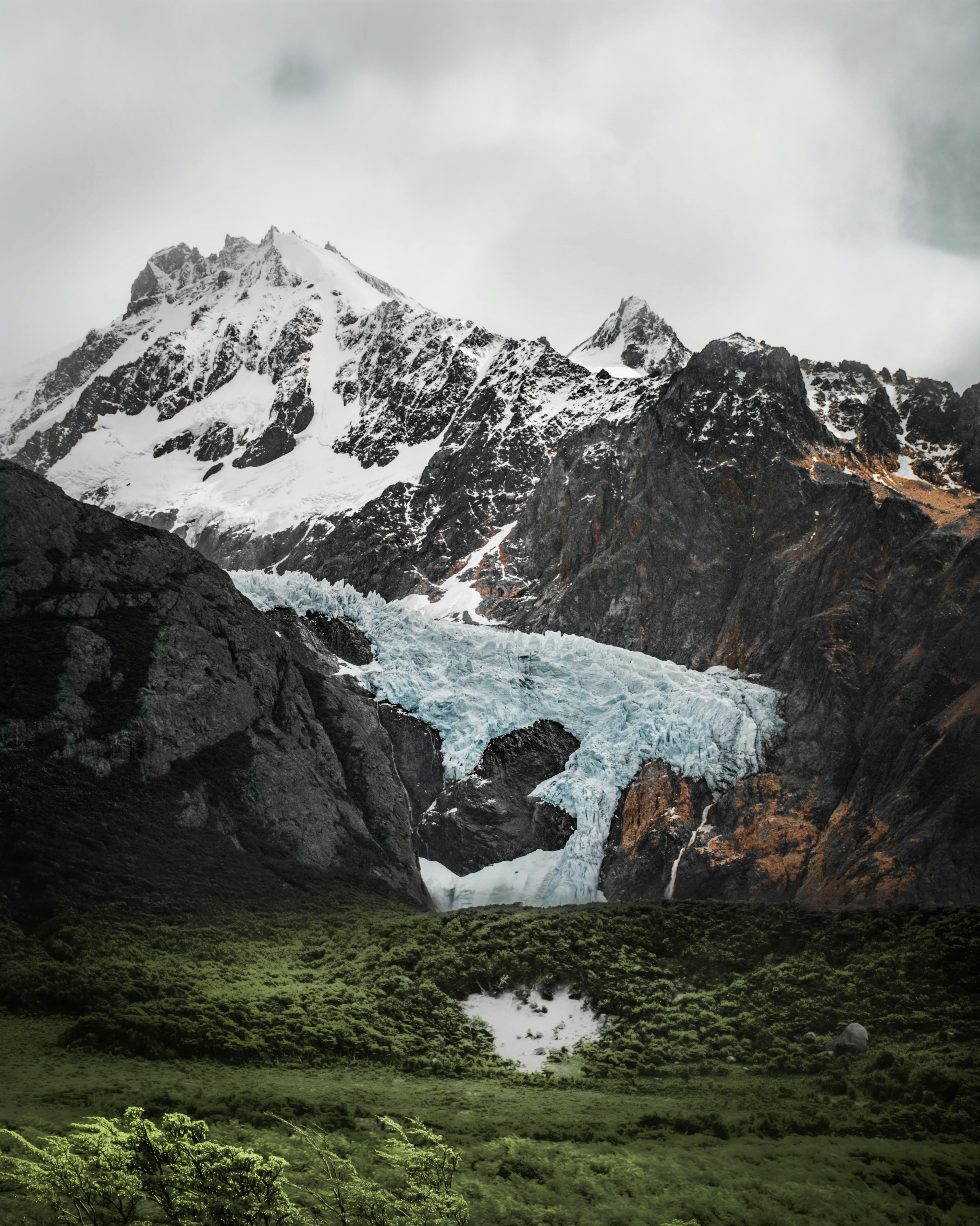 Scenic landscape of snowcapped mountains and lush meadow in El Chalten, Argentina.