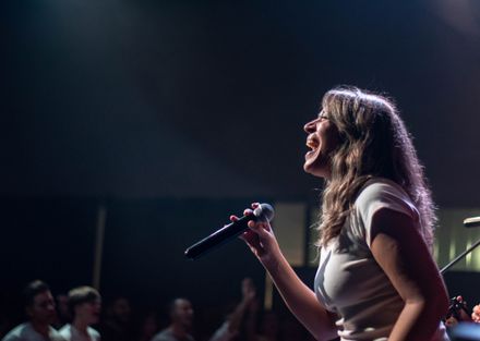 Singer performing on a small club stage — photo by Franco Monsalvo on Pexels