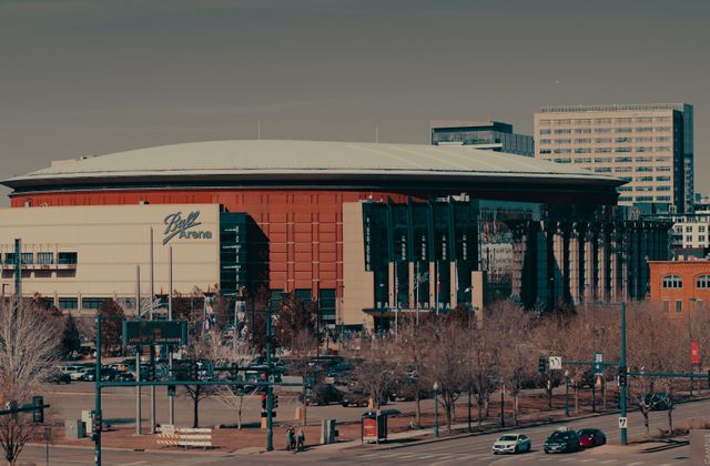 A daylight view of Ball Arena amidst Denver's urban landscape, highlighting its architectural design. — arriving in Denver